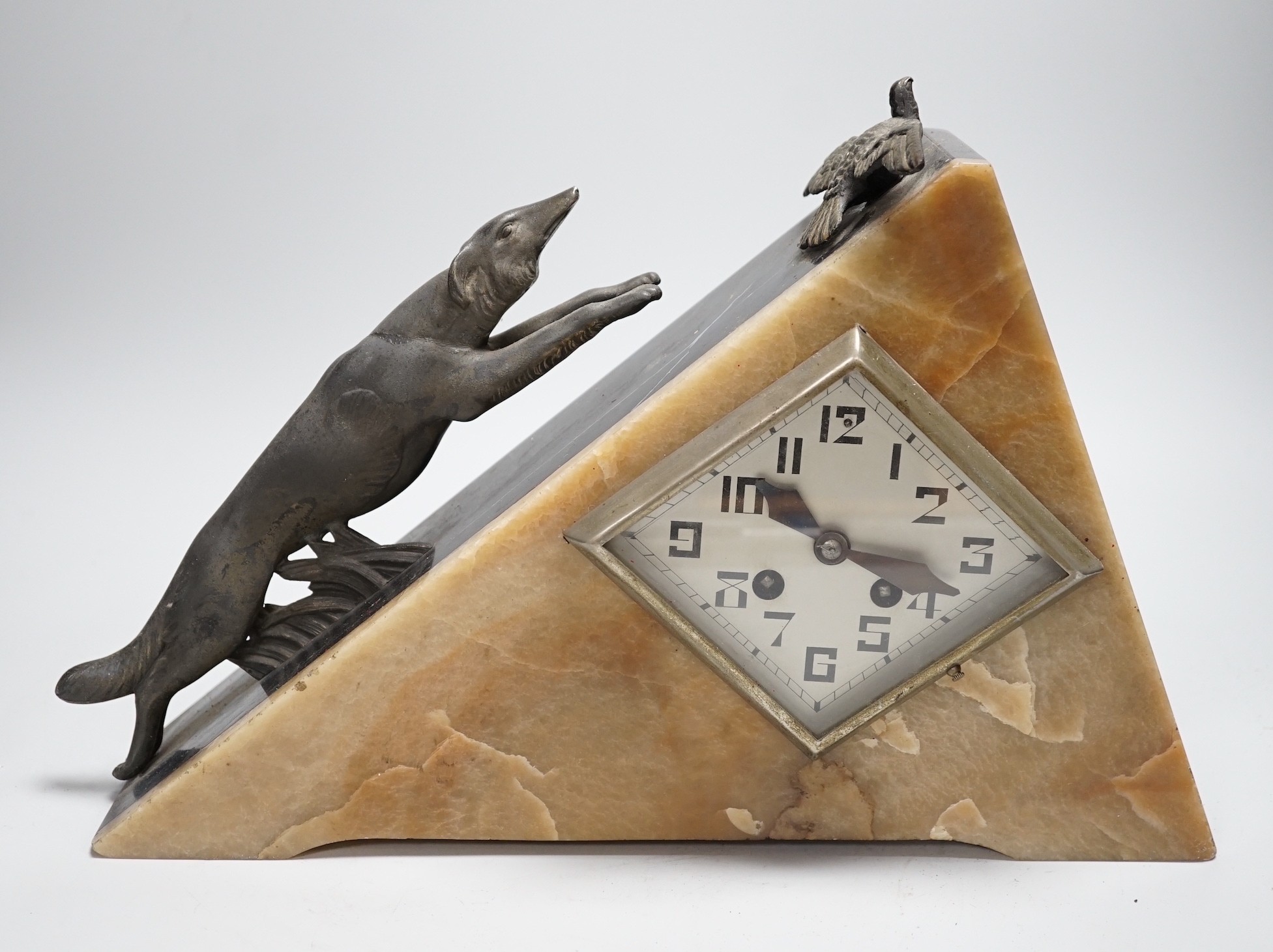 An Art Deco triangular marble and spelter clock, mounted with a fox chasing a bird, 39cms wide